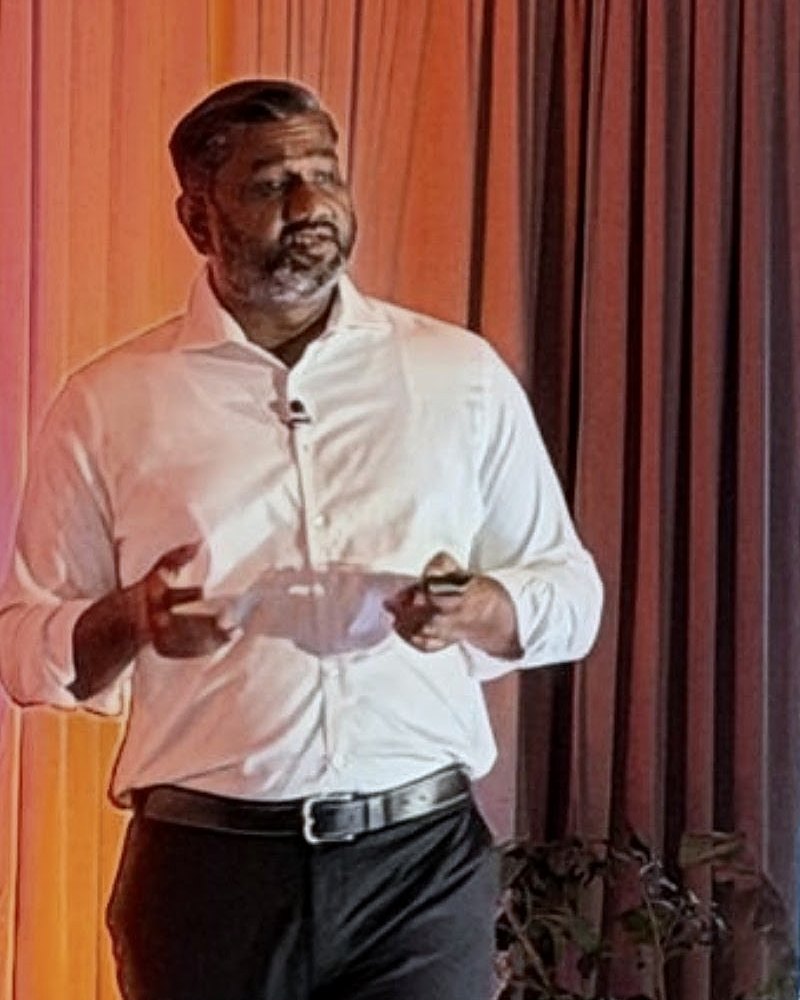 Muthu Bommiah presenting on stage